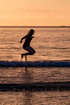 Silhouette of female swimmer going into the Atlantic ocean in Ireland.