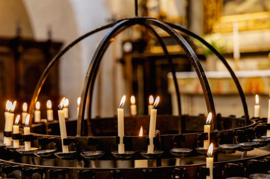 Lit candles in a candelabra in a church. Concept of spirituality and faith.
