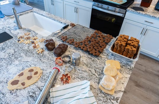 In a contemporary white kitchen, gingerbread cookie dough is skillfully rolled out, setting the stage for a delightful holiday treat.