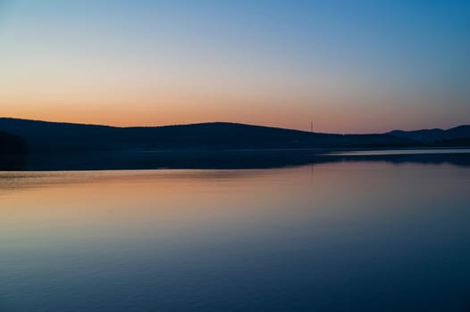 A calm and silent evening at sunset at the summer lake