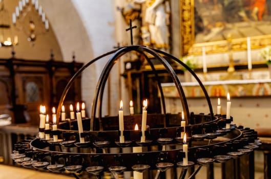 Lit candles in a candelabra in a church. Concept of spirituality and faith.
