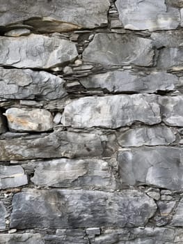 Close-up view of a textured gray slate wall with varied stone sizes and subtle color variations.