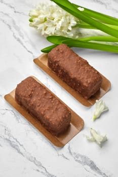 Artisan chocolate nut loaf cakes, perfect combination of texture and taste, presented on marble backdrop with delicate white hyacinth