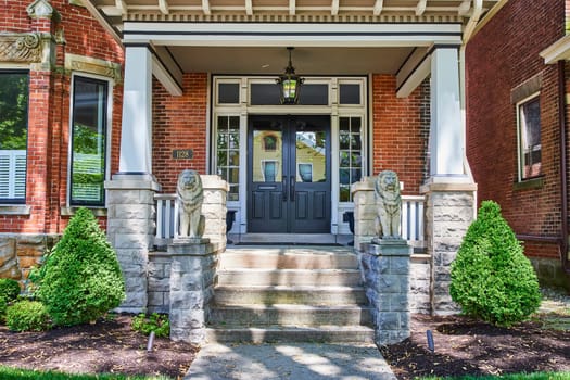 Elegant suburban home in Fort Wayne with lion-guarded entrance, showcasing traditional architectural charm.