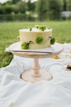 A delicious cake rests gracefully on a rustic table by a peaceful lake, surrounded by the beauty of nature.