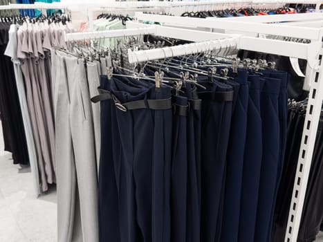 Row of hanged men Several different pants in a shop. Clothes store. . High quality photo