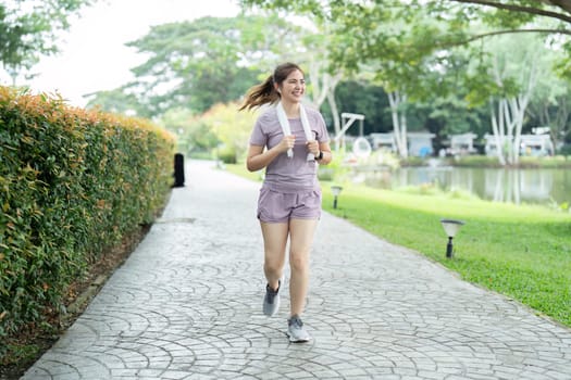 Young asian woman enjoying a morning run in a park. Workout exercise in the morning. Healthy and active lifestyle concept.