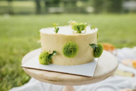 A luscious yellow cake adorned with vibrant green flowers on top, creating a beautiful and whimsical dessert centerpiece.