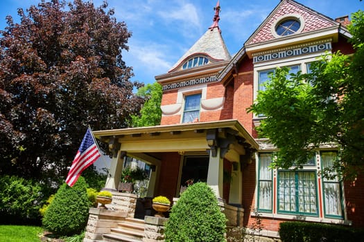 Victorian-style home in Fort Wayne, Indiana, adorned with an American flag, showcasing historical elegance and national pride.