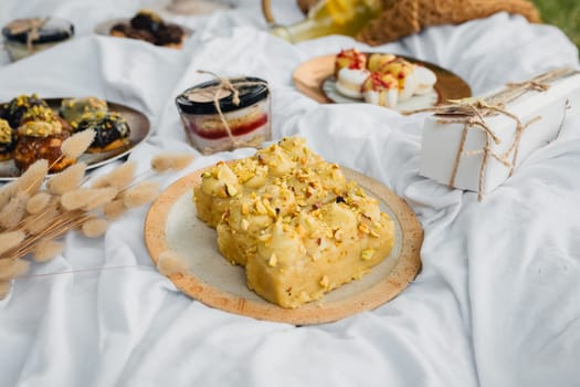 A picnic table adorned with a scrumptious array of food and desserts ready to be enjoyed outdoors.