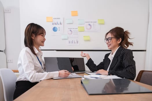 Young business woman and colleague are discussing company work documents..