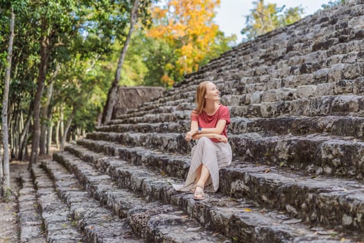 Woman tourist at Coba, Mexico. Ancient mayan city in Mexico. Coba is an archaeological area and a famous landmark of Yucatan Peninsula. Cloudy sky over a pyramid in Mexico.