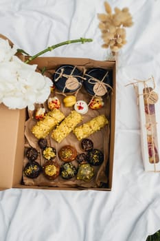 A colorful assortment of snacks and flowers displayed in an ornate box, creating a perfect blend of flavors and beauty.