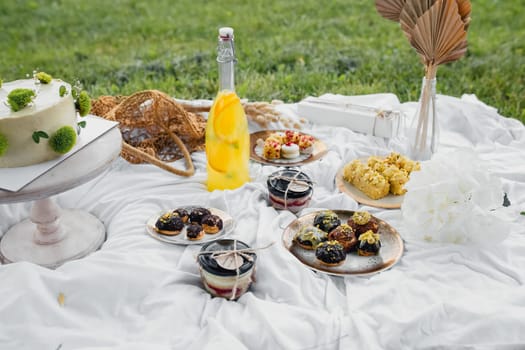 A picnic table laden with various delicious foods and refreshing drinks, ready for a delightful outdoor meal with friends or family.