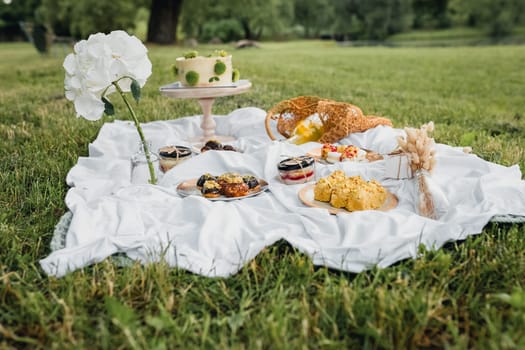 Friends enjoying a picnic in the park, surrounded by lush greenery, laughter, and delicious food.