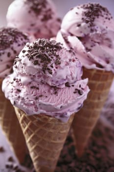 Three pink ice cream cones filled with creamy chocolate ice cream, creating a sweet and indulgent treat.