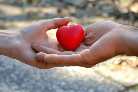 A man holding a red heart in his hand, symbolizing love and compassion.