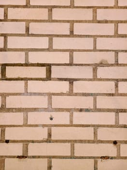Close-up of a weathered beige brick wall in Fort Wayne, showcasing natural textures and subtle color variations.