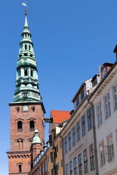 Downtown Copenhagen with old houses and church on a sunny day.