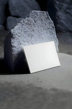 A blank white sheet of paper placed on a background of a large stone.