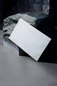 A blank white sheet of paper placed on a background of a large stone.