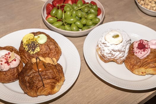 Delicious Mardi Gras buns with cream on a white plate.