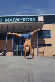 A talented man performs a perfect handstand in front of a majestic building, showcasing strength and balance.