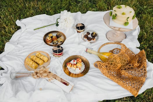 A colorful picnic blanket adorned with various foods and drinks, perfect for a relaxing outdoor meal on a sunny day.