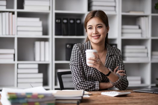 Portrait of a confident Asian business woman Working in a modern office desk using a laptop computer marketing concept.