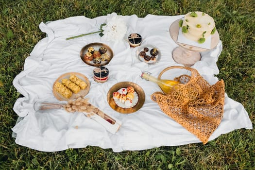 A vibrant picnic blanket with an assortment of delicious food and refreshing drinks laid out for a relaxing outdoor meal.