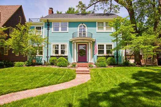Charming turquoise home with a purple door and American flag, nestled in Fort Wayne's historic South Wayne district.