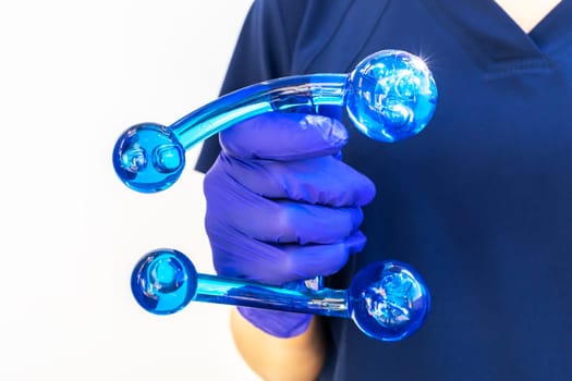 Doctor Holds Blue Acrylic Back, Leg, Neck Massage Tool with Gloved Hand. Deep Tissue Massage, Thumb Massager with Knobs for Gentle Point, Muscles Relaxation. Horizontal. High quality photo