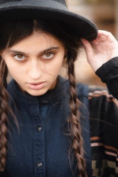 A striking young lady wearing chic black clothing and a hat. High quality photo