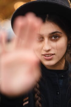 An enchanting woman, exuding boho style, wears a black hat as she strolls through the fall city streets. High quality photo