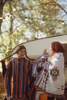 Two fashionable women exude bohemian vibes against the trailer background. High quality photo
