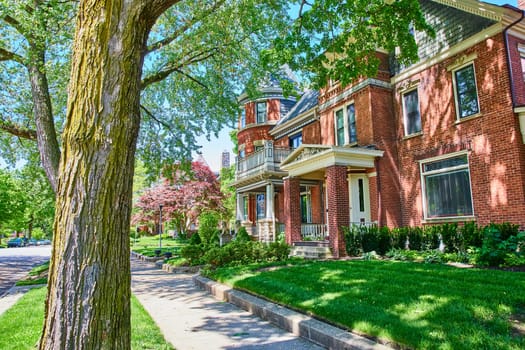 Stately red-brick Victorian home in historic Fort Wayne, Indiana, showcasing architectural elegance and lush landscaping.