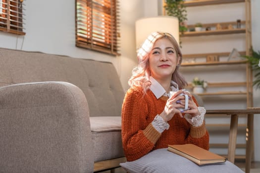 Beautiful young woman drinks coffee and tea in the morning Sit back and relax in the living room..