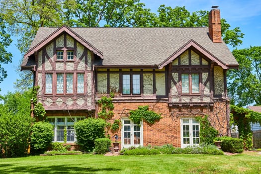 Charming Tudor-style home in South Wayne Historic District, Fort Wayne, surrounded by lush greenery.