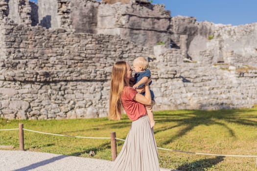 Mother and son tourists enjoying the view Pre-Columbian Mayan walled city of Tulum, Quintana Roo, Mexico, North America, Tulum, Mexico. El Castillo - castle the Mayan city of Tulum main temple.