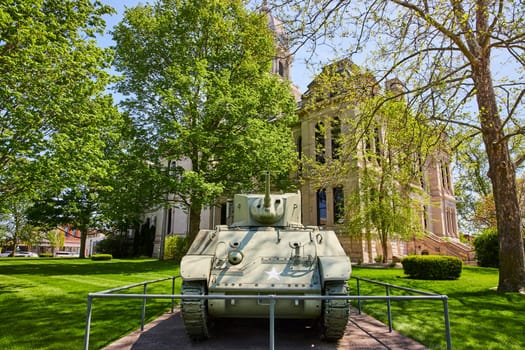 Vintage U.S. military tank in front of Kosciusko County Courthouse, Indiana, symbolizing peace and history.