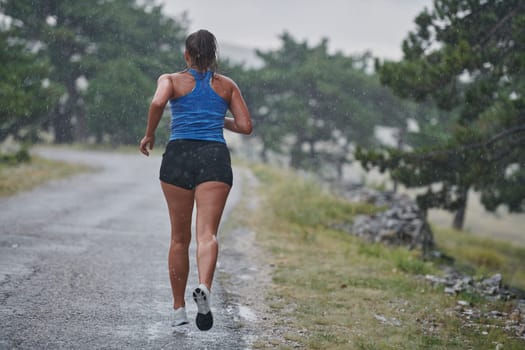 Rain or shine, a dedicated marathoner powers through her training run, her eyes set on the finish line.