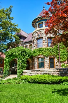 Historic Fort Wayne mansion in lush garden, epitome of early 20th-century luxury and charm.