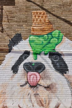 Vibrant panda graffiti with green ice cream, on a sunny downtown Fort Wayne mural.