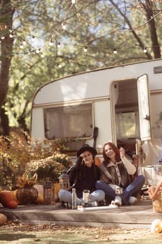 A pair of trendy gals don boho-chic attire against the trailer backdrop. High quality photo