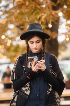 A vibrant, stylish girl in a black hat, sporting a braided hairstyle. High quality photo