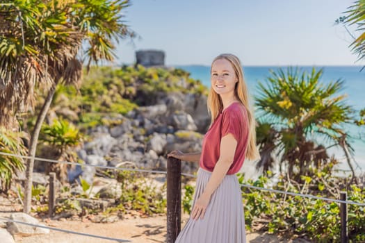 Woman tourist enjoying the view Pre-Columbian Mayan walled city of Tulum, Quintana Roo, Mexico, North America, Tulum, Mexico. El Castillo - castle the Mayan city of Tulum main temple.