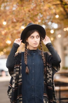 A beautiful young woman in black attire and a hat. High quality photo