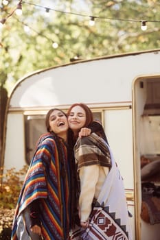 A duo of trendy girls flaunt their boho style against the trailer backdrop. High quality photo