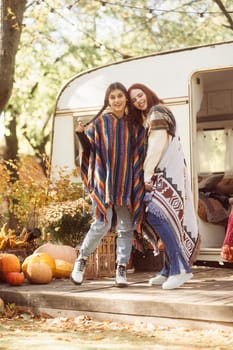 Two hip girls showcase their hippie-inspired outfits against the trailer setting. High quality photo