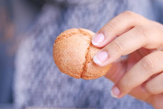 young woman holding a sweet cookie .